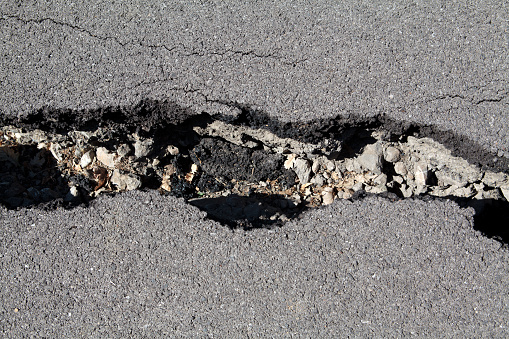 damaged road with crack of asphalt.