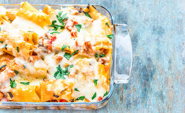 Baked Pasta Baked cheesy rigatoni pasta with celery leaves. rigatoni stock pictures, royalty-free photos & images