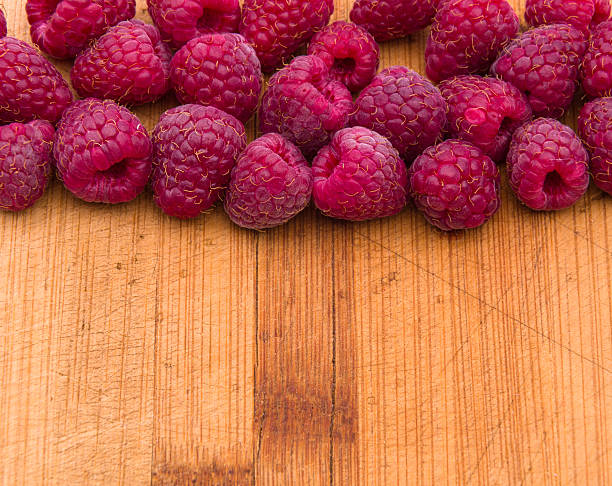 istock Ripe sweet raspberries on wood table close-up 500200610