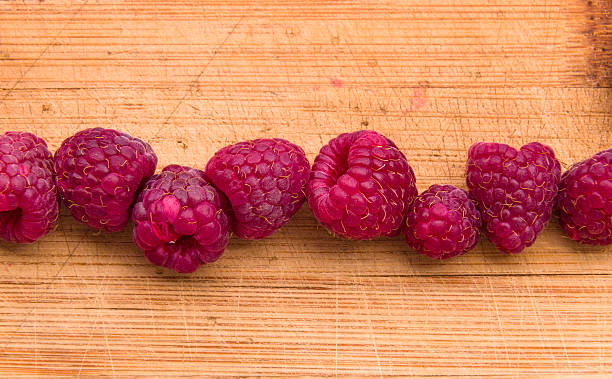 istock Ripe sweet raspberries on wood table close-up 500200638