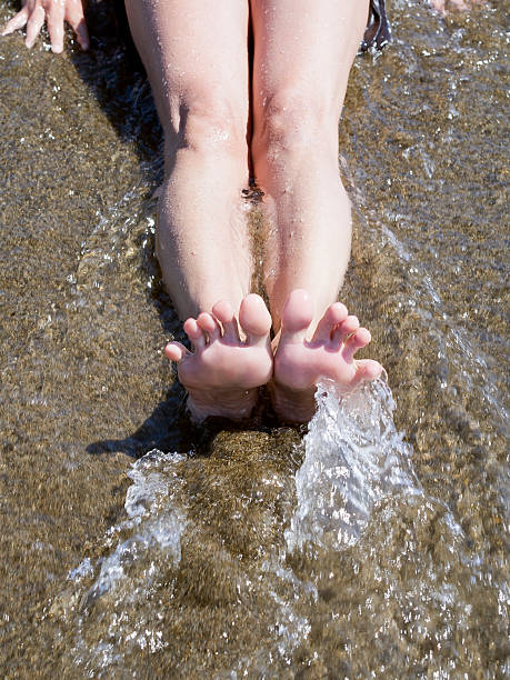 istock woman feet relaxing on the shore waiting for  wave 500201373