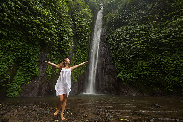 istock woman meditating doing yoga between waterfalls 500202894