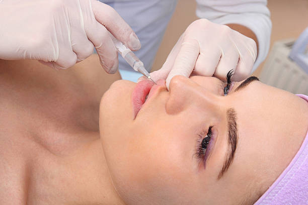 istock Beautiful woman gets an injection in her lips. 500204394