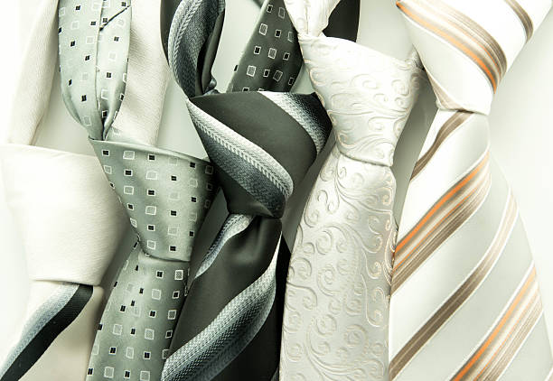 A rolled up striped brown and white tie isolated on white background.