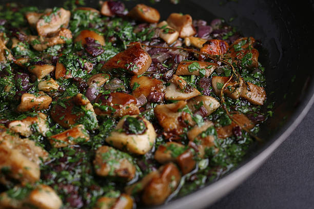 Fried mushrooms with onions and greens in a skillet on