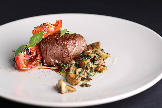 istock Roasted meat with tomatoes and mushrooms on a white plate 500211930