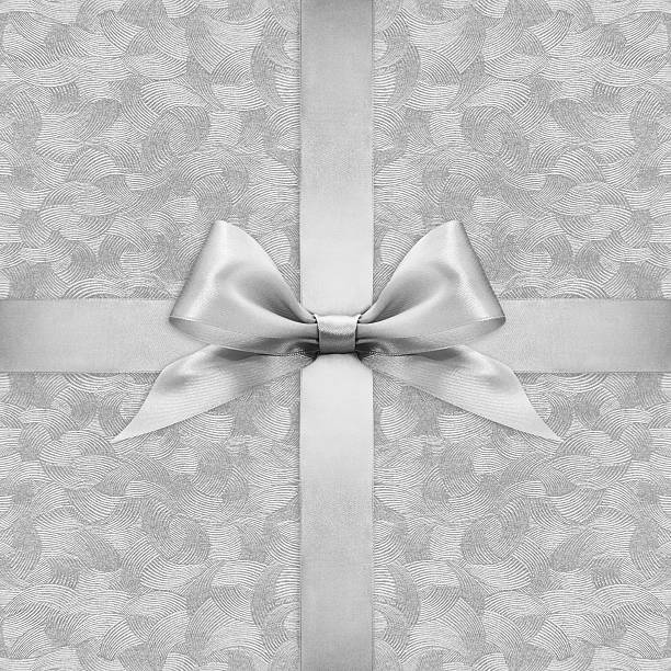 istock Shiny silver satin ribbon bow on argent background 500212486