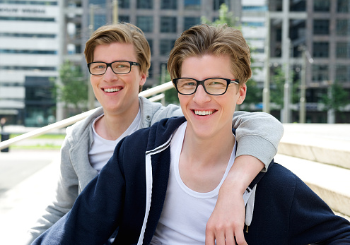 Close up portrait of two happy brothers smiling together outdoors
