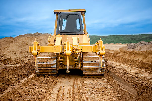 istock Bulldozer with steel blade moving soil and sand around 500215769