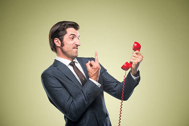 Nerdy Office Worker With Vintage Telephone Nerdy office worker with attitude, flipping off a rotary vintage phone. slicked back hair stock pictures, royalty-free photos & images