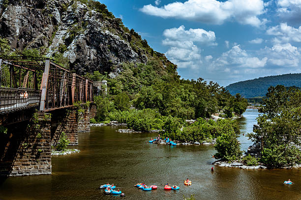 Drifting on the River people floating on the Shenandoah River beneath a historic bridge. harpers ferry photos stock pictures, royalty-free photos & images