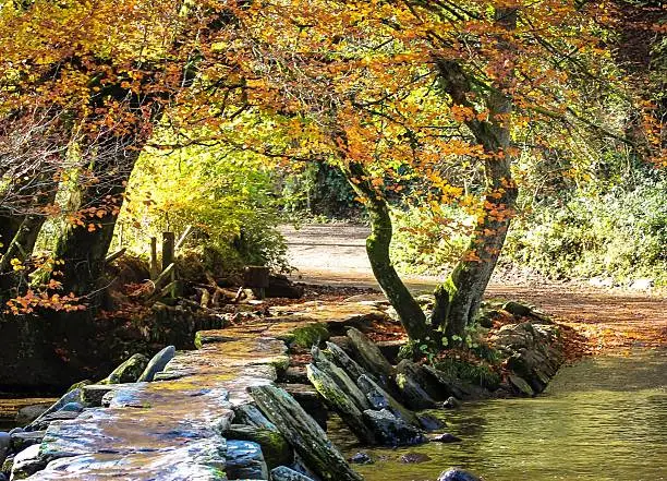 Photo of Tarr Steps a Clapper bridge across the River Barle in the Exmoor National Park, Somerset, England.