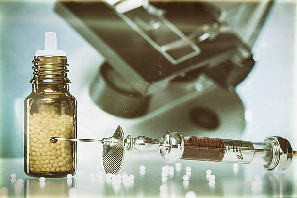 istock homeopathy globules, syringe with blood and microscope 500216593