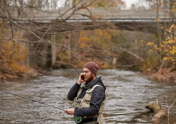 Shot of a young man talkign on his cellphone while out fishing by a riverhttp://195.154.178.81/DATA/i_collage/pu/shoots/806068.jpg