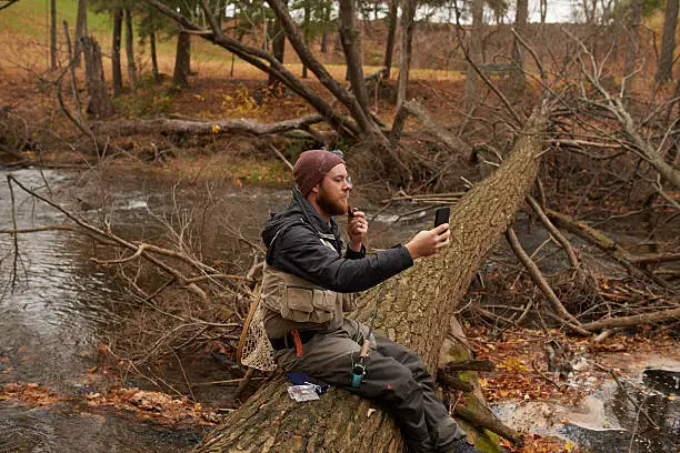 Shot of a young man taking a photo with his cellphone while out fishing by a riverhttp://195.154.178.81/DATA/i_collage/pu/shoots/806068.jpg