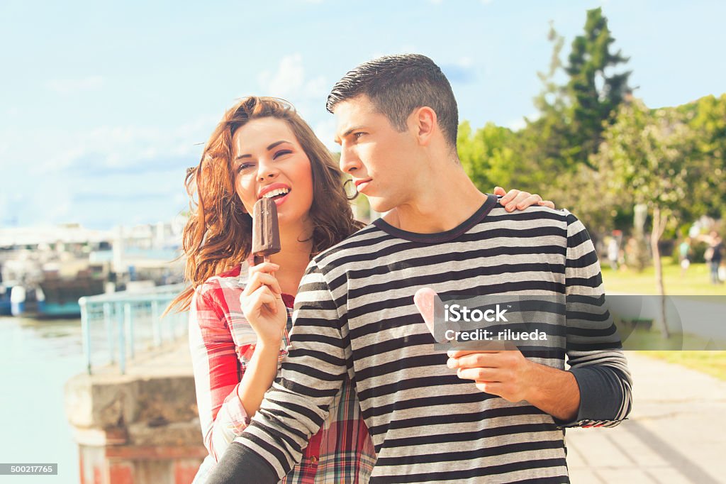 Happy couple eating ice cream outdoors on a sunny day Young couple eating ice cream on a sunny day Ice Cream Stock Photo