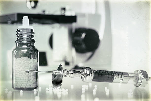 istock homeopathy globules, syringe with blood and microscope 500218263