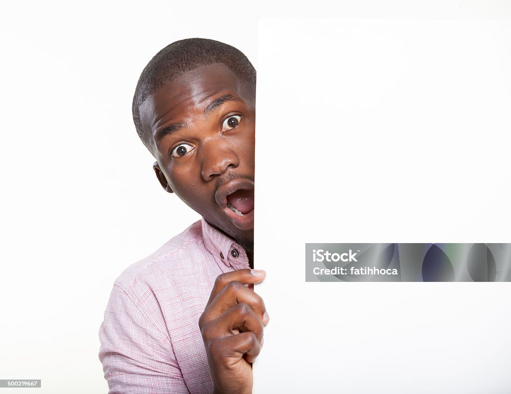 Surprise Young man peeking placard. 16-17 Years Stock Photo