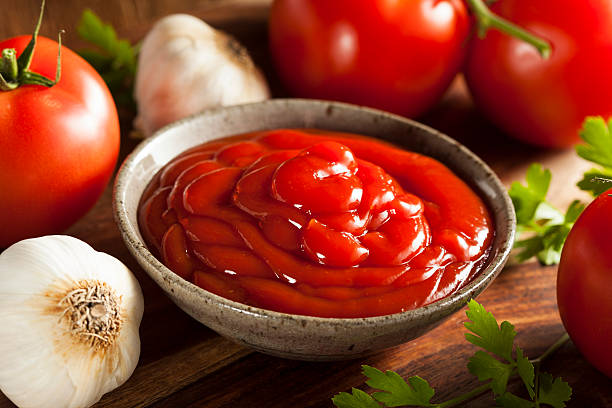 Organic Red Tomato Ketchup Organic Red Tomato Ketchup in a Bowl etchup stock pictures, royalty-free photos & images