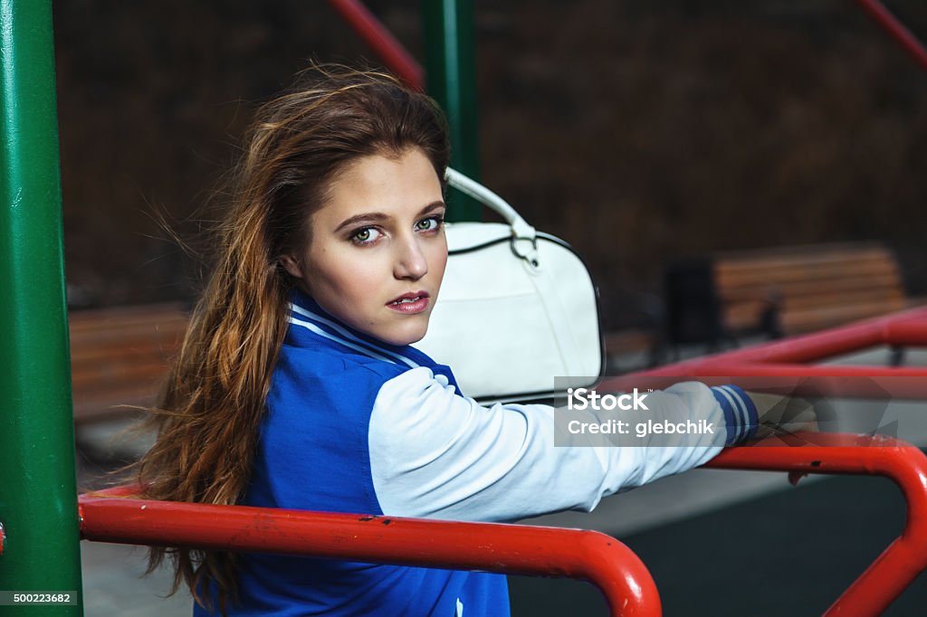 Fashionable beautiful girl stands on sports ground Pretty young student holding simulator on open air 2015 Stock Photo