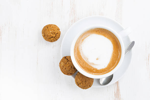 eine tasse cappuccino und leckeren cookies auf weißer holztisch - biscotti coffee cappuccino latté stock-fotos und bilder