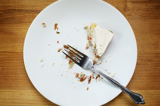 Plate with half eaten piece of cake.