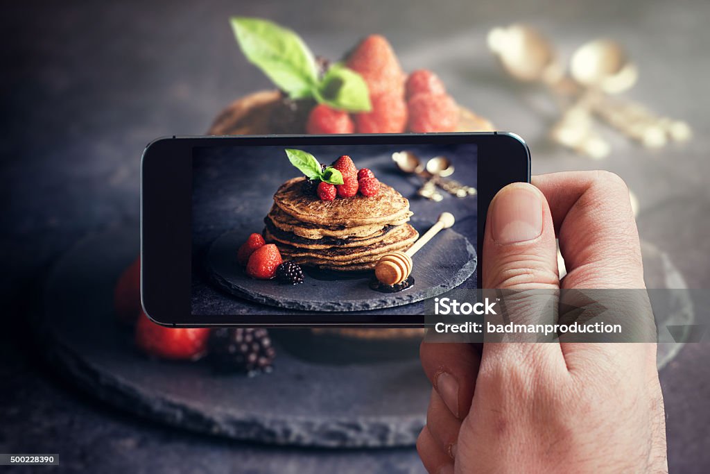 Buckwheat pancakes with fruit Man photographing wit his phone buckwheat pancakes with fruit Food Stock Photo