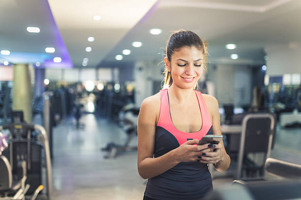 istock Smiling woman with smartphone on treademill 500229280