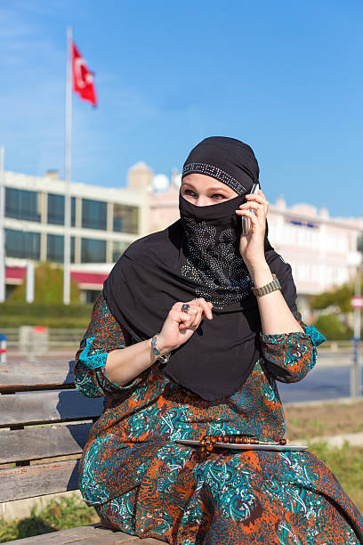 istock Lady in Black Hijab Holding Telephone and talking 500229618
