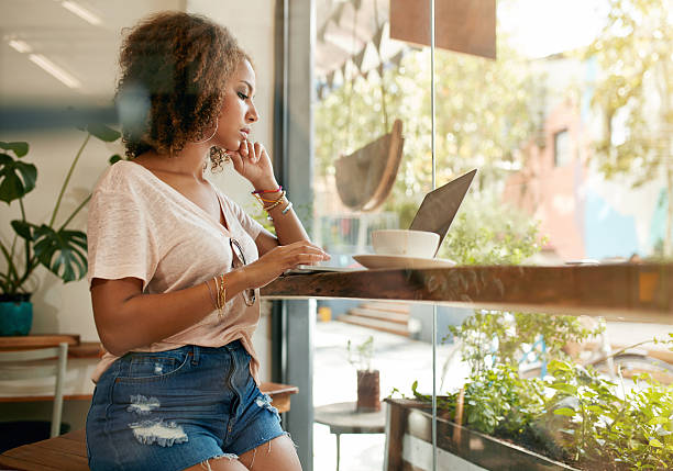 istock Young woman using her laptop in a coffee shop 500229940