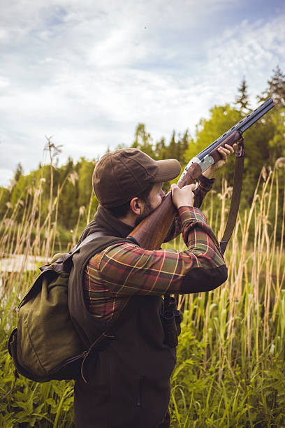istock Hunter Pointing a Gun to the Sky In Swamp 500234076