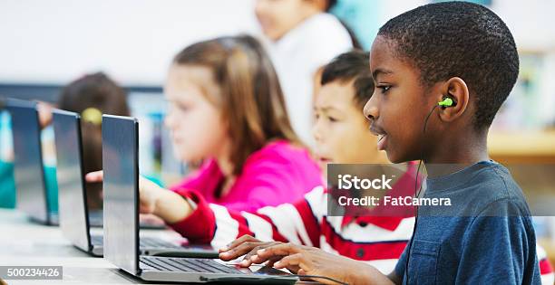 Listening To Music From The Web Stock Photo - Download Image Now - Child, Technology, Classroom
