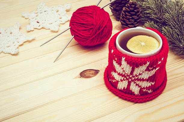 Retro toned knitted Christmas decorations and tea Retro toned knitted Christmas decorations and hot tea with lemon pine needle tea stock pictures, royalty-free photos & images