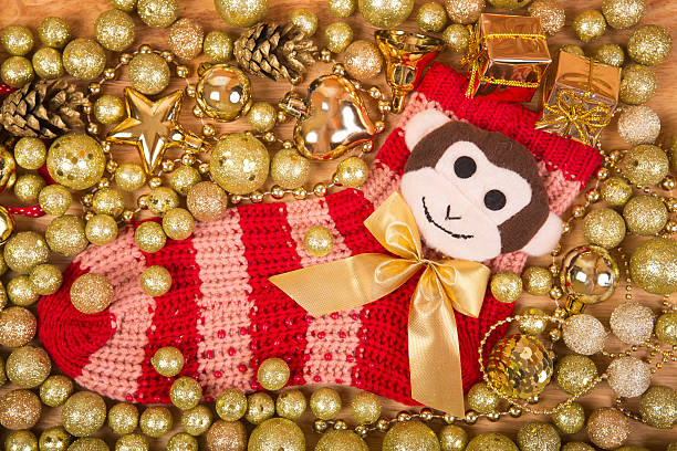 istock Christmas background with gold balls and monkey on red sock 500234886
