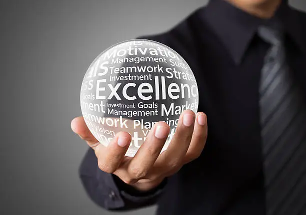 Businessman hand showing excellence word in crystal ball