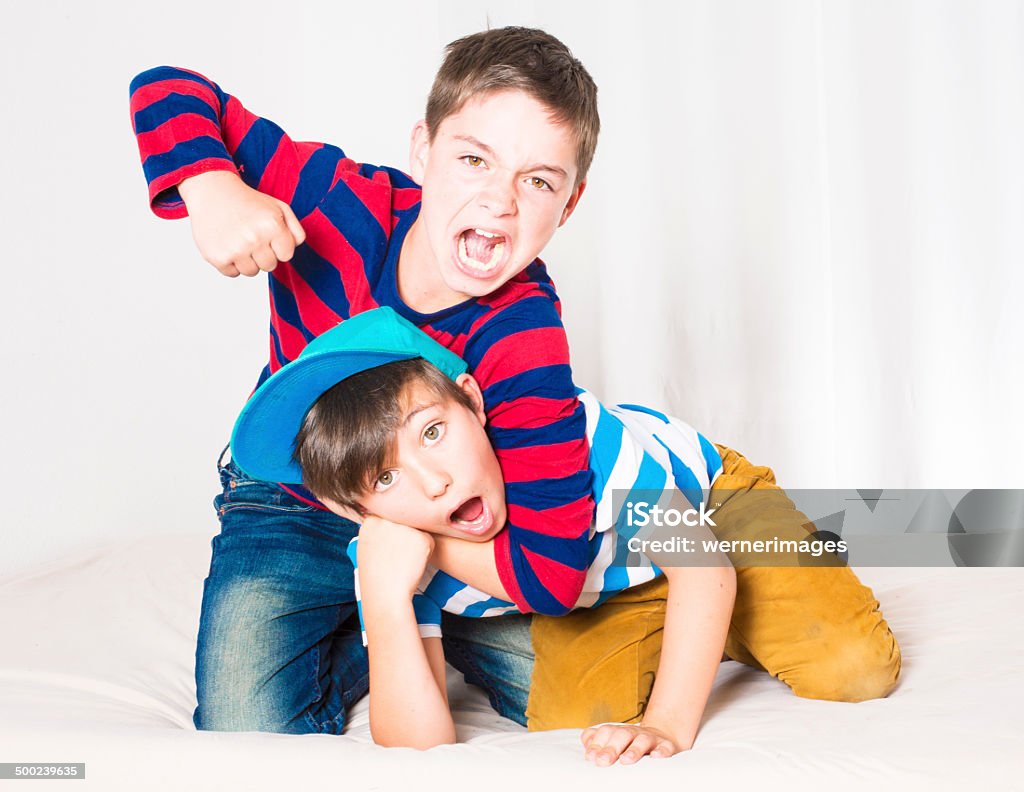 two boys fighting two young boys in bed and fighting Boys Stock Photo