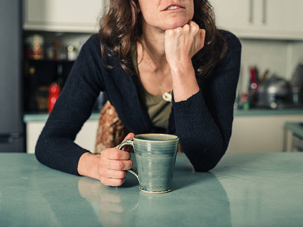 istock Young woman daydreaming with coffee in kitchen 500251142