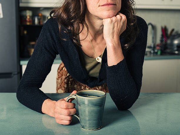 istock Young woman daydreaming with coffee in kitchen 500251256