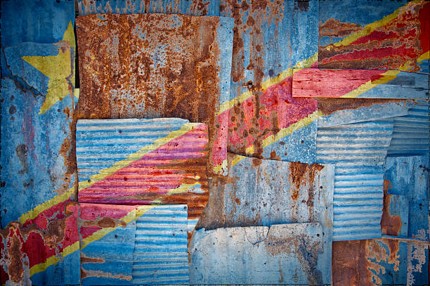 Corrugated Iron Congo Kinshasa Flag An abstract background image of the flag of Congo Kinshasa painted on to rusty corrugated iron sheets overlapping to form a wall or fence. kinshasa stock pictures, royalty-free photos & images