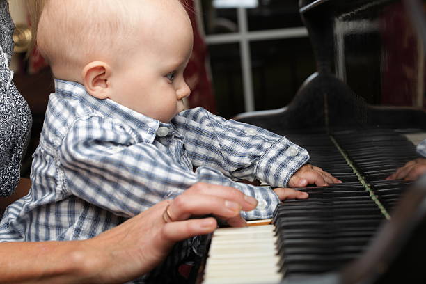istock beautiful little baby boy plays piano 500254184