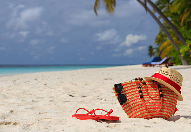 istock hat, bag, sun glasses and flip flops on tropical beach 500255119