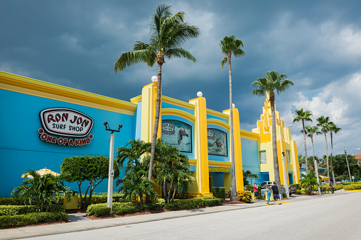 Cocoa Beach, Florida, USA - June 21, 2014: People exit Ron Jon Surf Shop, a landmark in Cocoa Beach, Florida. Thunderstorm clouds gather in the background.