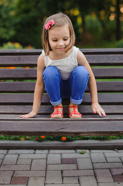 istock Little cute girl sits on bench 500262972