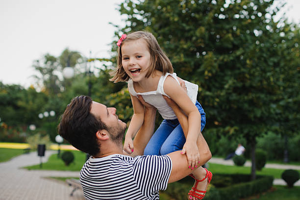 istock Dad playing with his daughter in park 500263280