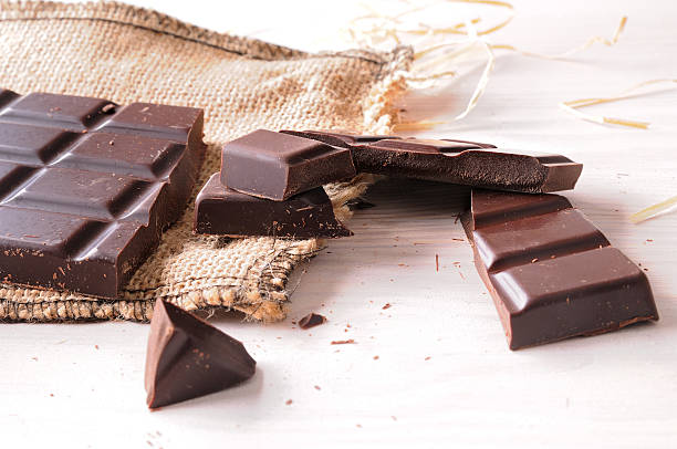 istock Broken tablet artisan chocolate on a wooden table elevated view 500263724