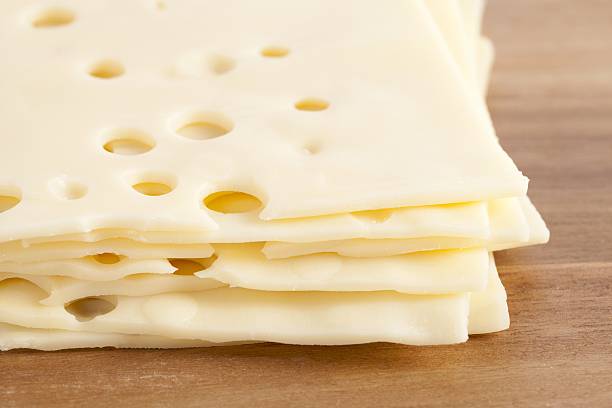 fette di formaggio svizzero - swiss cheese foto e immagini stock