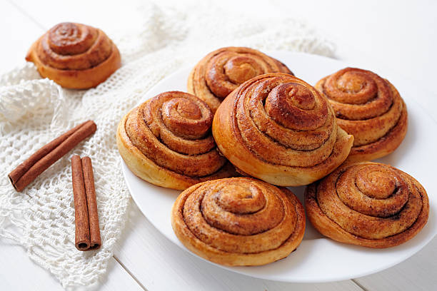 Sweet cinnamon bun rolls christmas delicious dessert on white vintage Sweet cinnamon bun rolls christmas delicious dessert on white vintage table. Traditional swedish kanelbullar baked pastry kanelbulle stock pictures, royalty-free photos & images