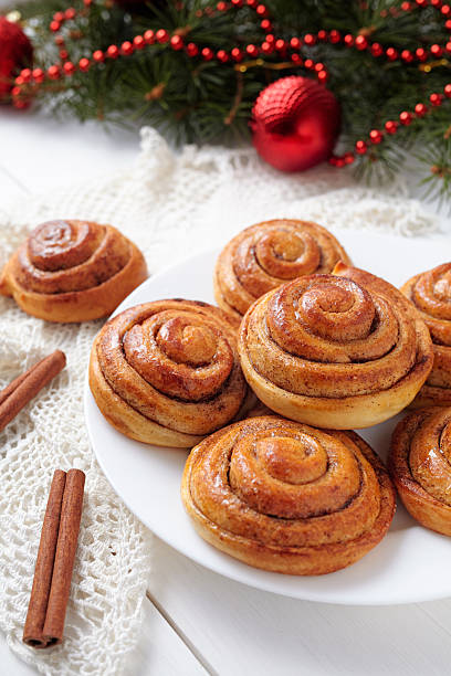 Cinnamon bun rolls christmas sweet dessert on white vintage table Cinnamon bun rolls christmas sweet dessert on white vintage table with new year decorations. Traditional swedish kanelbullar baked pastry kanelbulle stock pictures, royalty-free photos & images