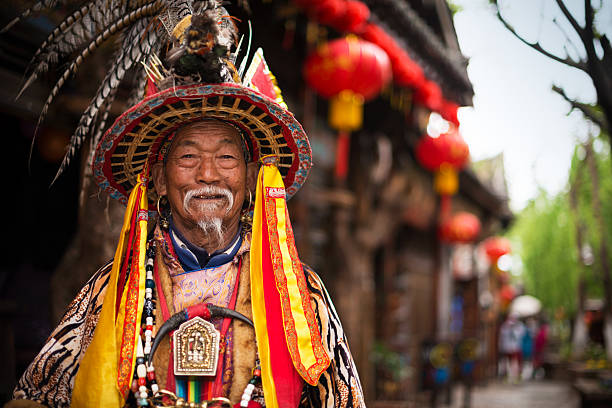 Lijiang, China - March 30, 2014: A Naxi nationality old man smiling and welcome the travelers. Located in Lijiang, Yunnan, China.
