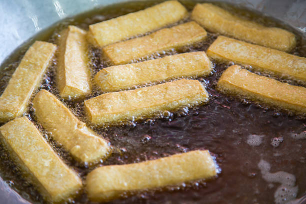 istock frying tofu  with hot oil in a big pan. 500288661